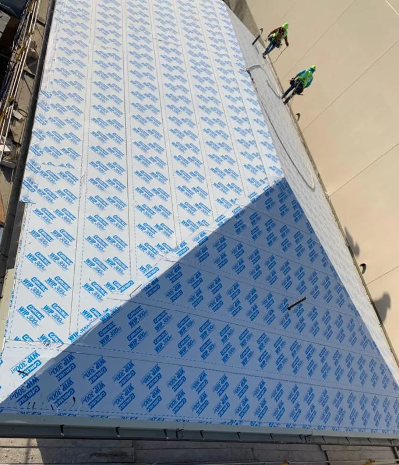 Professional roofers installing underlayment on a metal roof in Elkhart